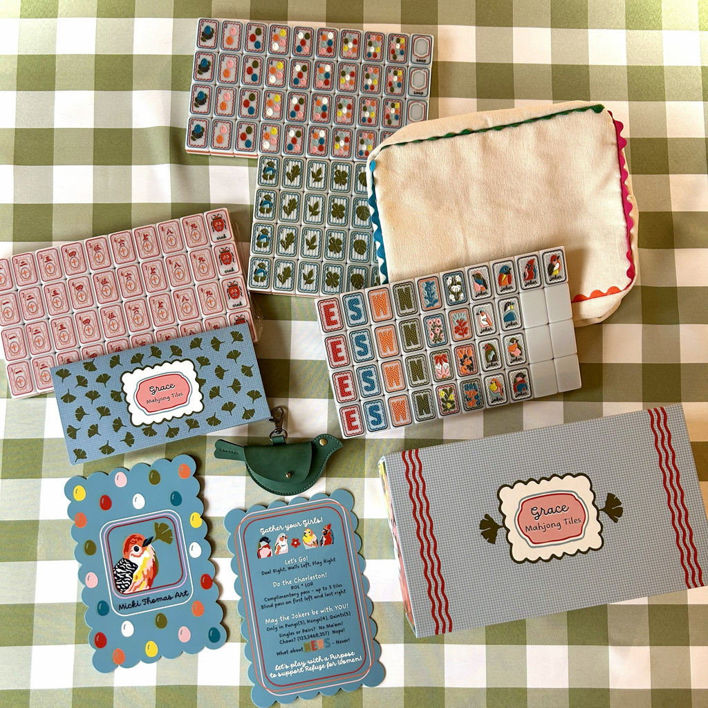 Collection of decorative mahjong cards and shufflers on a checkered tablecloth