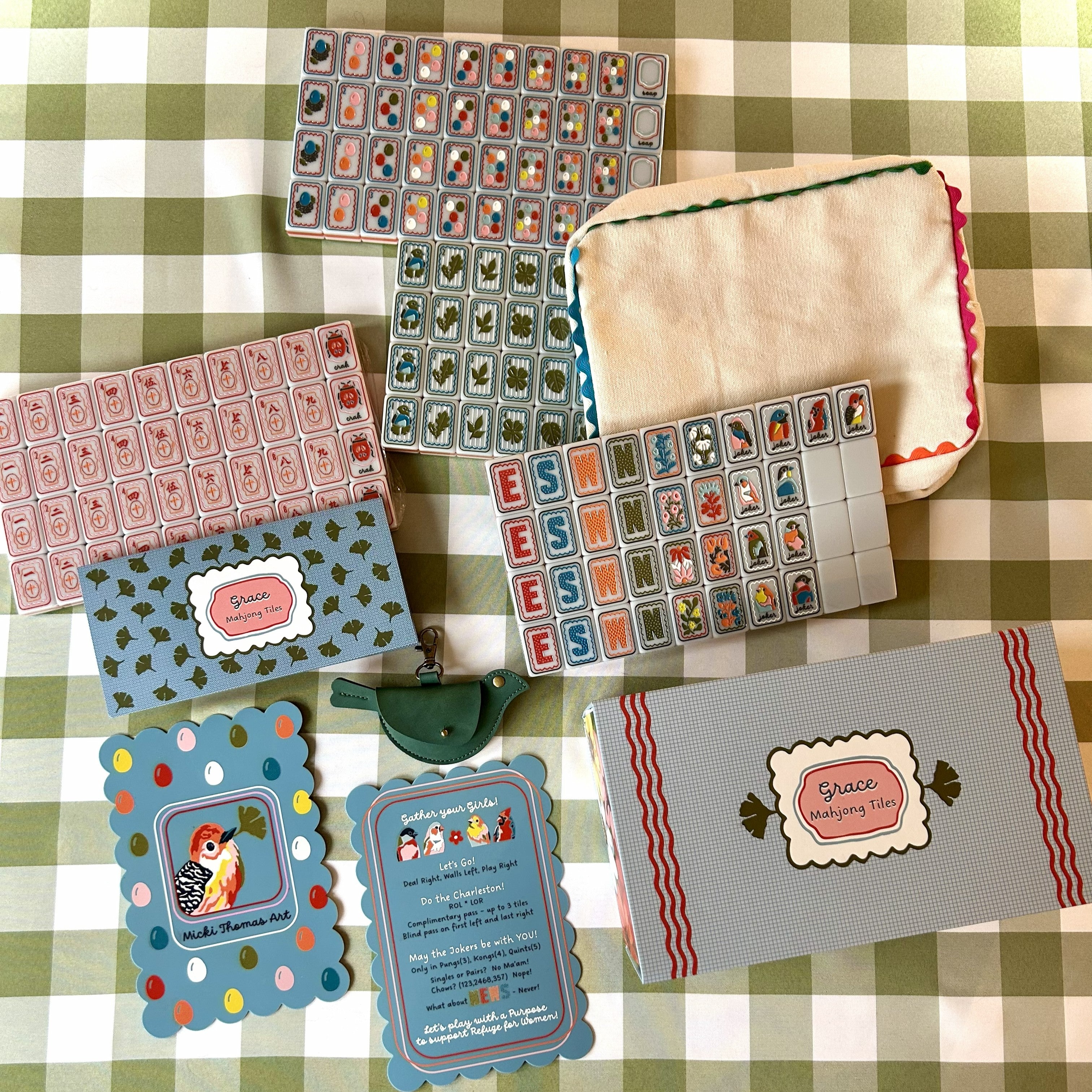 Collection of decorative mahjong cards and shufflers on a checkered tablecloth