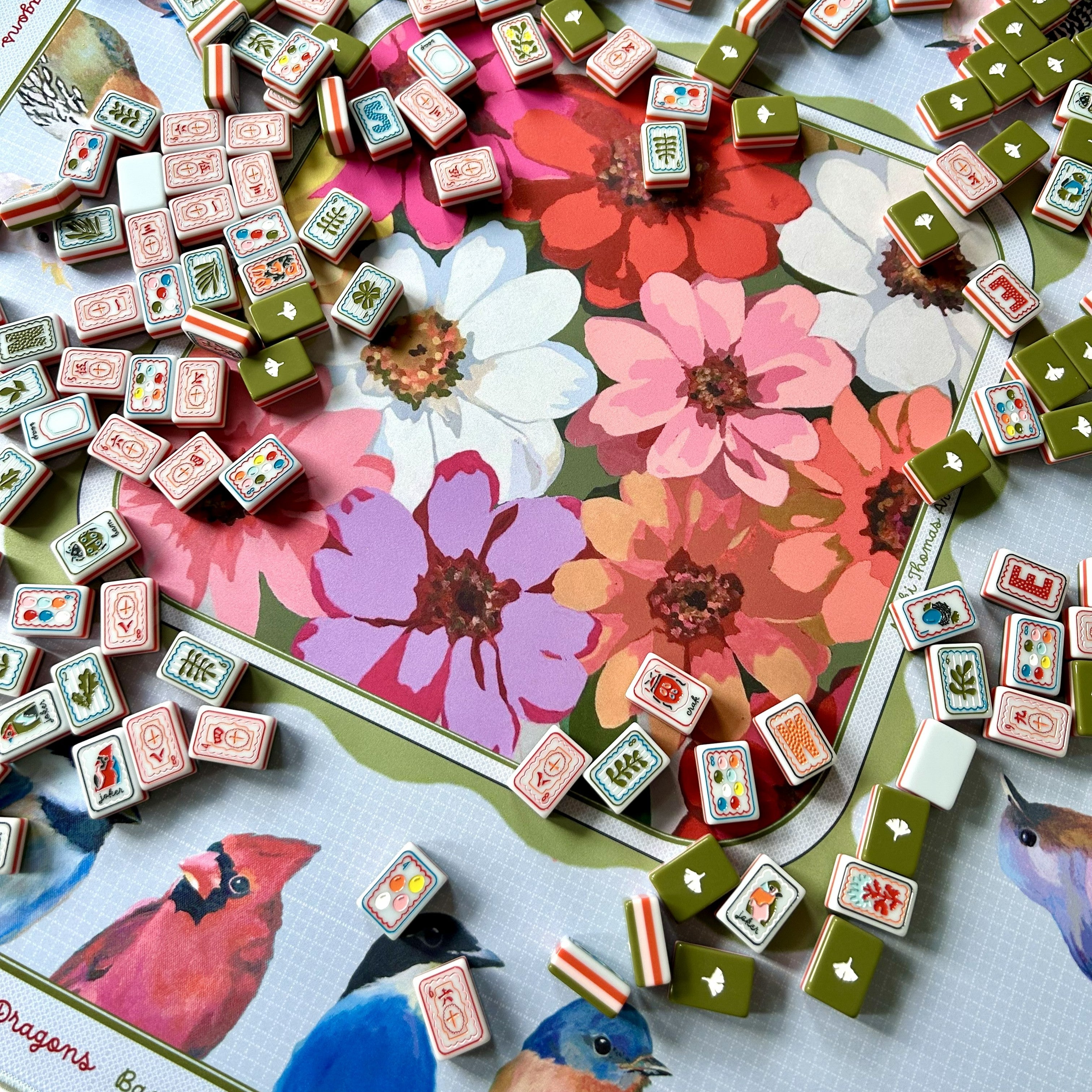 Mahjong mat and tiles on a floral and nature-themed board